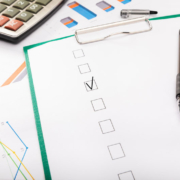 A checklist and pen on paper with one box marked off.